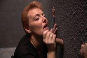 Rijpe roodharige slet op een orale gloryhole orgie